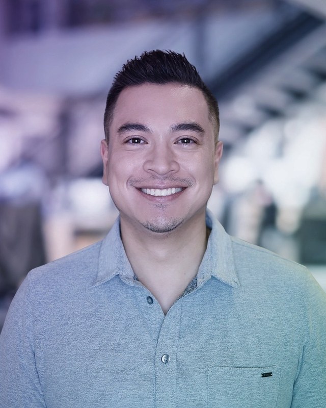 Portrait of Jeff Geronimo, smiling, in a light blue collared shirt.